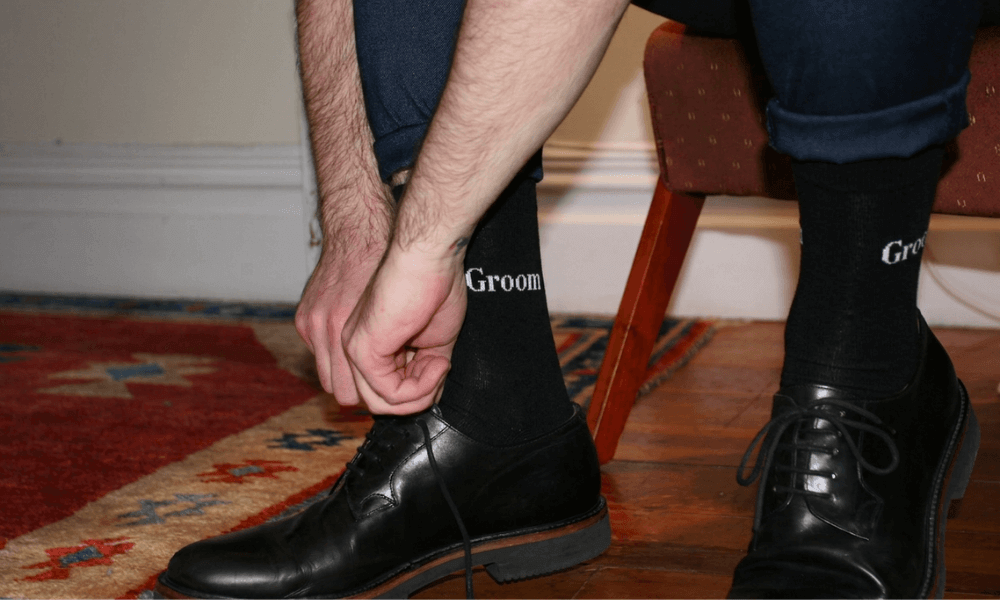 Groom adjusting his weddidng socks