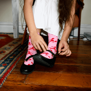 woman wearing pink and red crayfish crew socks with crayfish design